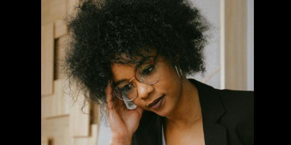 Black woman with glasses - report on financial stress and mental health for Black women